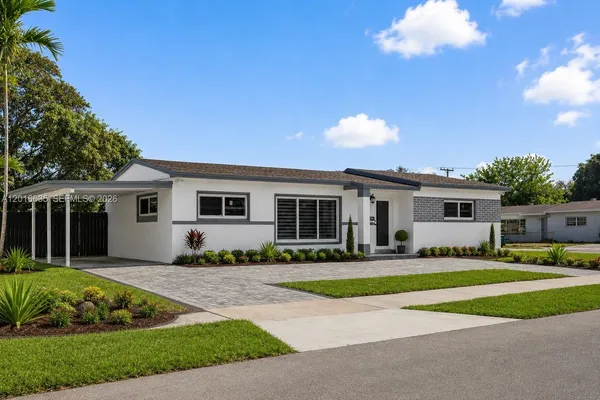 a front view of a house with a yard and trees
