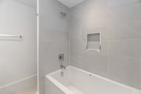 a white bath tub sitting next to a white sink and vanity