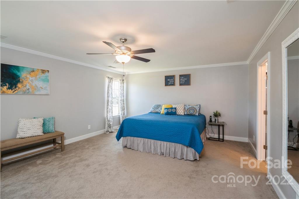 5113 Unionville Road Monroe, NC 28110 - Photo 24 of 43 a bedroom with a bed and a chandelier