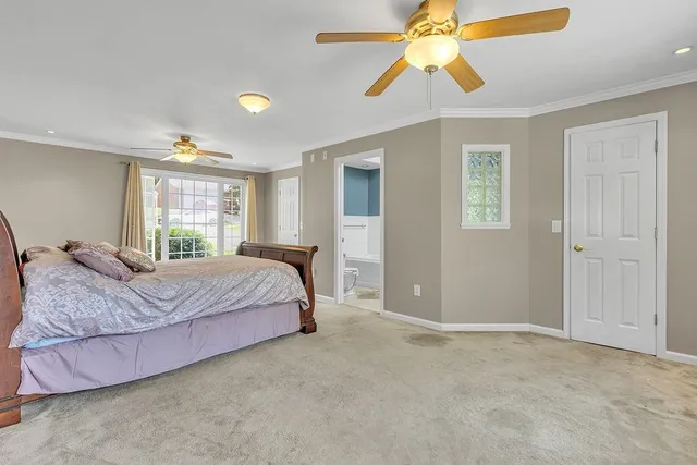 a spacious bedroom with a bed and a chandelier fan