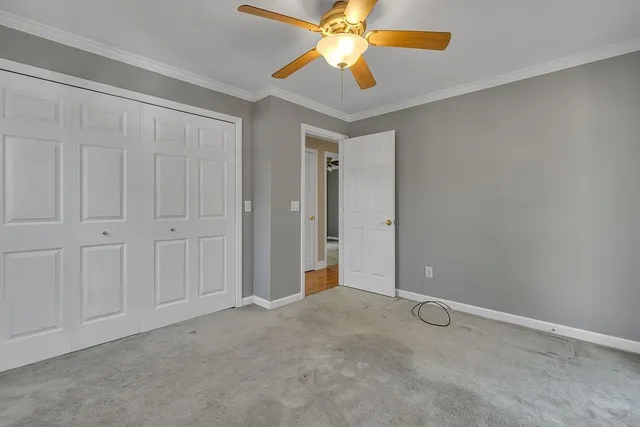 an empty room with closet and a chandelier fan