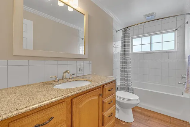 a bathroom with a granite countertop sink toilet and shower