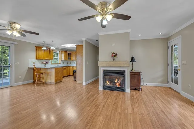 a view of a room with kitchen and fireplace wooden floor
