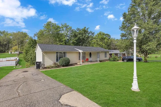 a front view of a house with a yard and trees