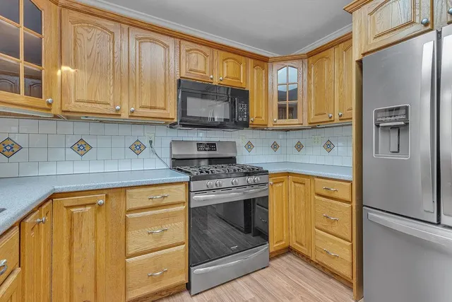 a kitchen with stainless steel appliances granite countertop a refrigerator stove and sink