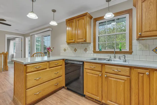 a kitchen with granite countertop wooden cabinets stainless steel appliances a sink and large window