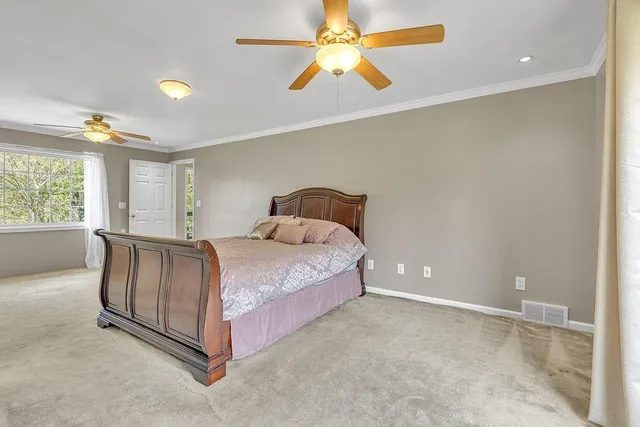 a spacious bedroom with a bed and a ceiling fan