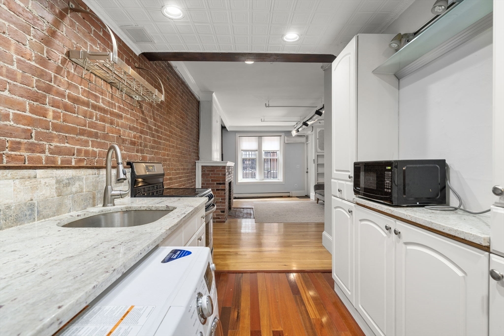 167 Beacon Street, Unit 2 Boston, MA 02116 - Photo 11 of 18 a large kitchen with granite countertop a sink and a stove top oven