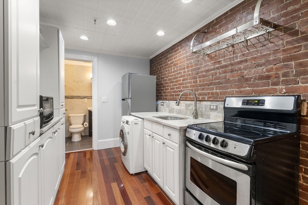 167 Beacon Street, Unit 2 Boston, MA 02116 - Photo 14 of 18 a kitchen with a stove and white cabinets