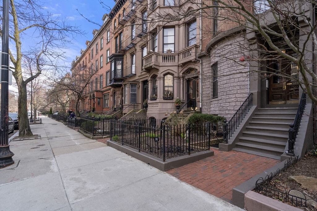 167 Beacon Street, Unit 2 Boston, MA 02116 - Photo 2 of 18 a view of a brick house with many windows next to a road