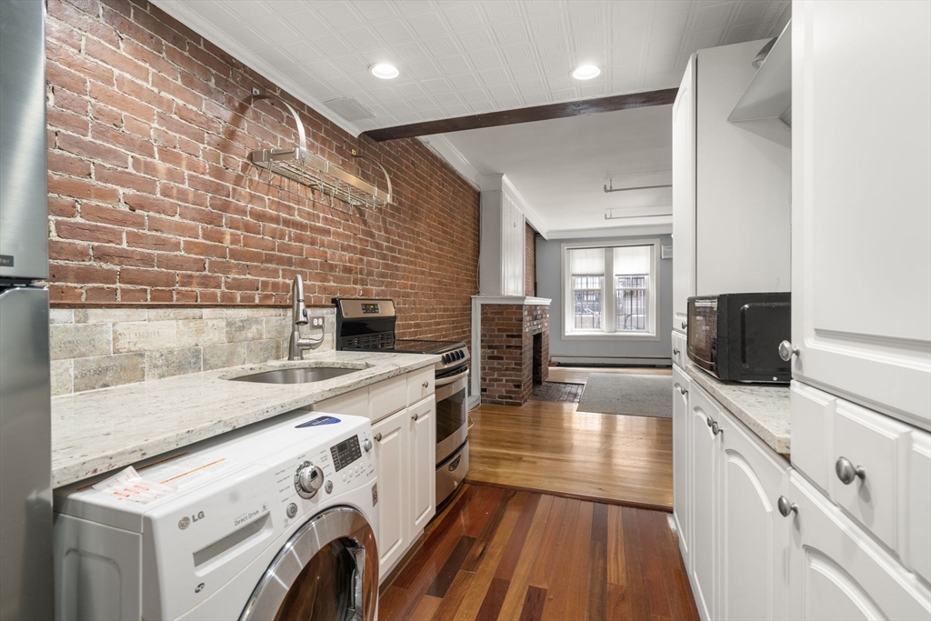 167 Beacon Street, Unit 2 Boston, MA 02116 - Photo 10 of 18 a view of a kitchen with a sink and wooden floor