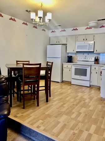 a kitchen with white cabinets and white appliances