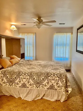 a view of a bedroom with a bed and wooden floor