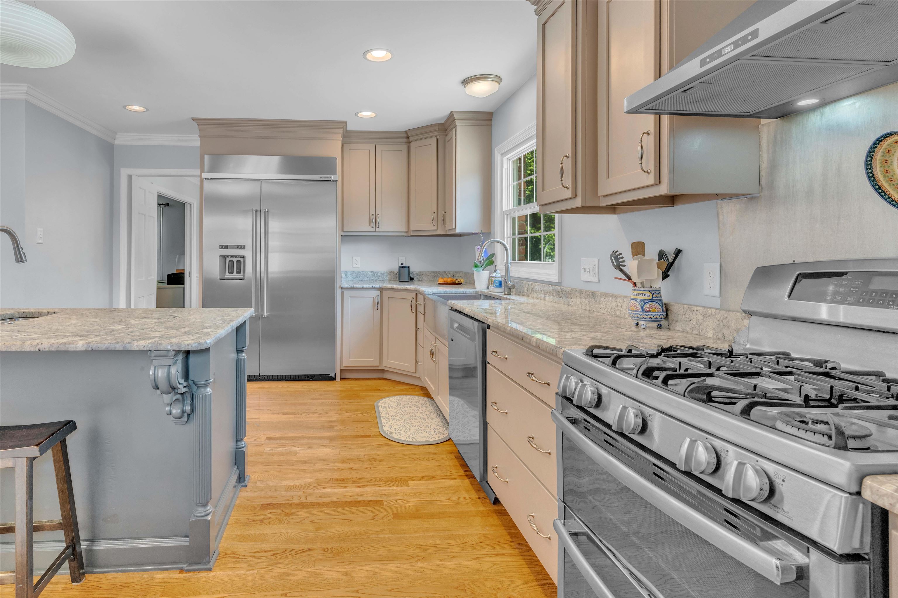 5187 South Angela Road Memphis, TN 38117 - Photo 12 of 39 Well-appointed kitchen featuring a stainless steel gas range, coordinating stainless steel refrigerator, light wood-finish flooring, stone countertops, and ample cabinetry