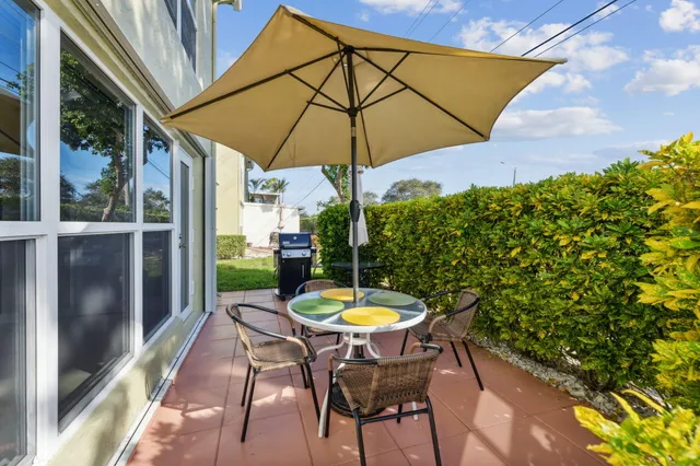 a outdoor view with a table and chairs under an umbrella