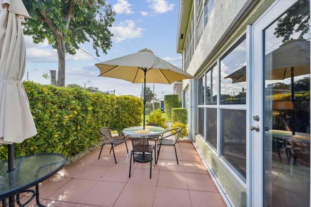 a view of a patio with a table and chairs under an umbrella