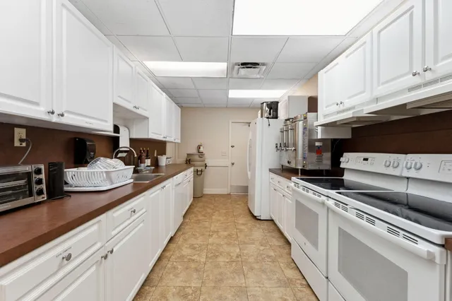 a large kitchen with stainless steel appliances granite countertop a lot of counter space