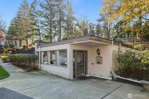 a view of a white building among the street with palm trees