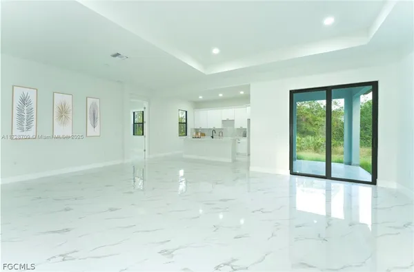 a large white kitchen with kitchen island a sink a stove and a refrigerator