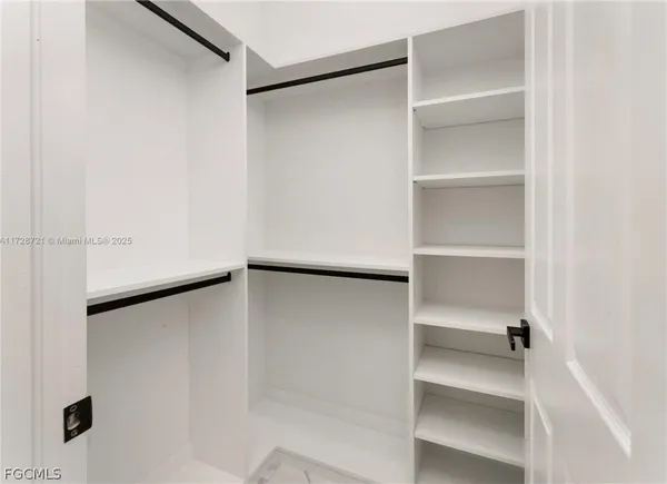 an empty room with fan and entrance