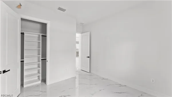 an empty room with closet and mirror