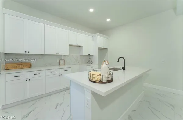 a kitchen with sink a stove and cabinets