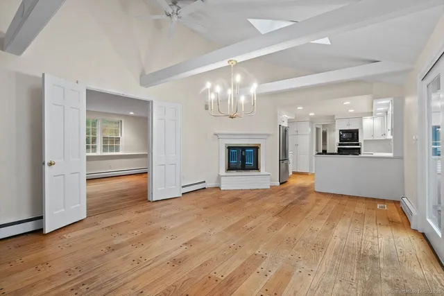 a view of an empty room with a fireplace and a window
