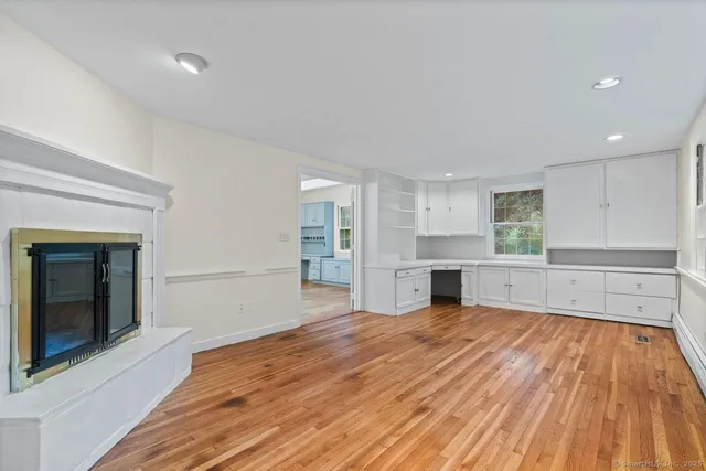 a view of empty room with wooden floor and fireplace