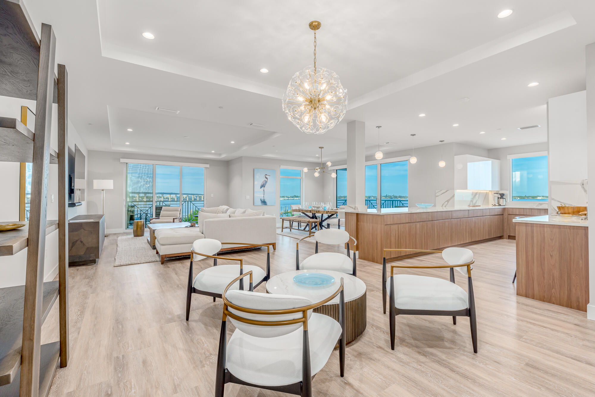 a view of a dining room and livingroom with furniture wooden floor a chandelier