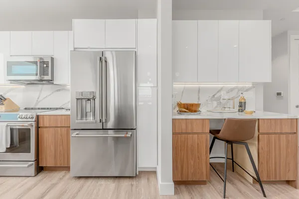 a kitchen with stainless steel appliances granite countertop a refrigerator and a stove top oven