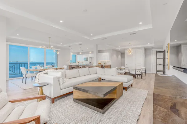a living room with furniture and a dining table with kitchen view