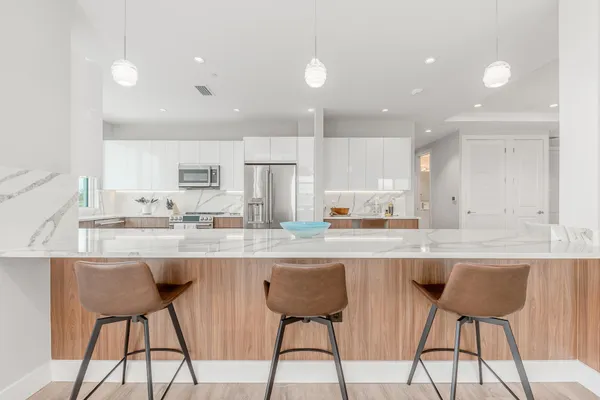 a kitchen with stainless steel appliances granite countertop a table and chairs in it