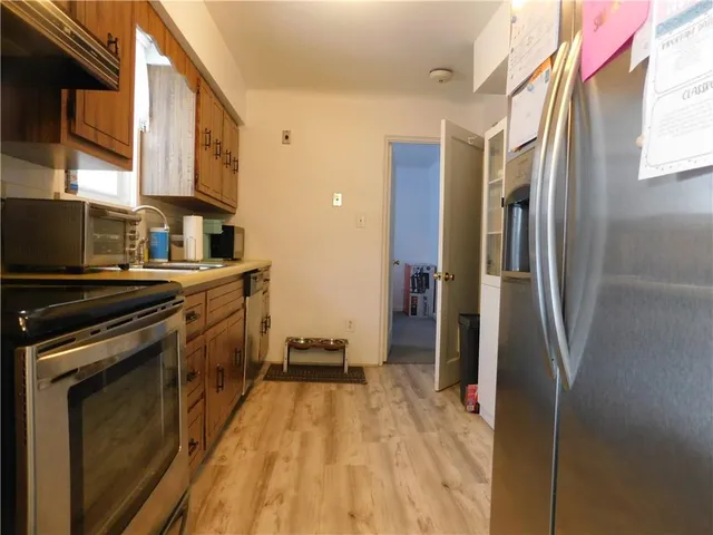 a kitchen with stainless steel appliances granite countertop a refrigerator a stove and a sink