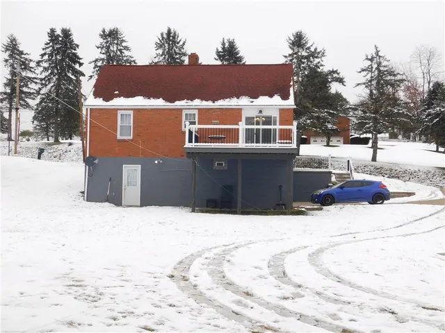 a front view of house with yard covered with trees