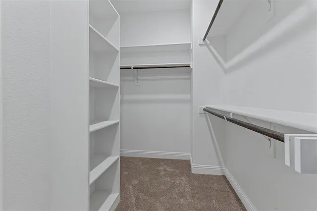 a view of walk in closet with empty racks