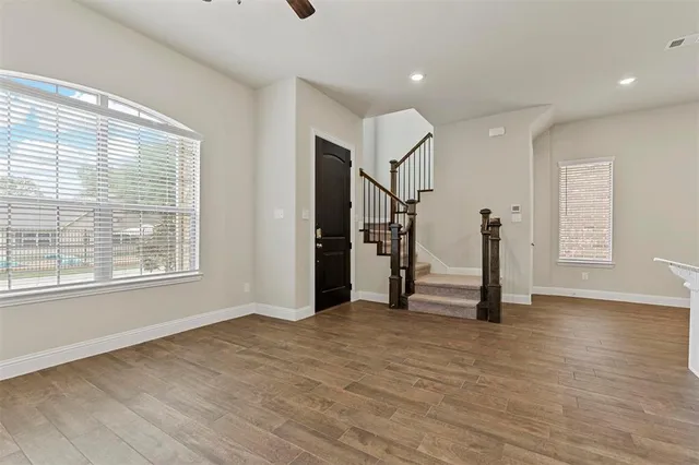 a view of empty room with wooden floor and window