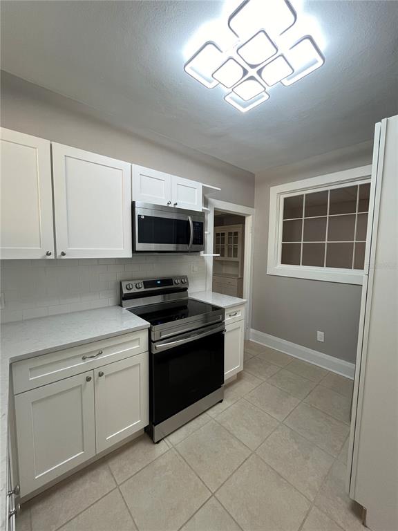 3303 West Empedrado Street, Unit 1 Tampa, FL 33629 - Photo 9 of 16 a kitchen with white cabinets stainless steel appliances and a sink