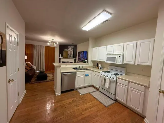 a kitchen with a sink cabinets stainless steel appliances and a window