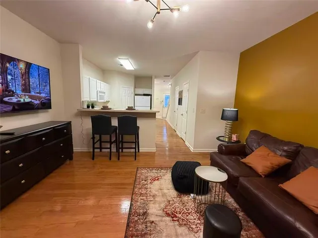 a living room with furniture and wooden floor