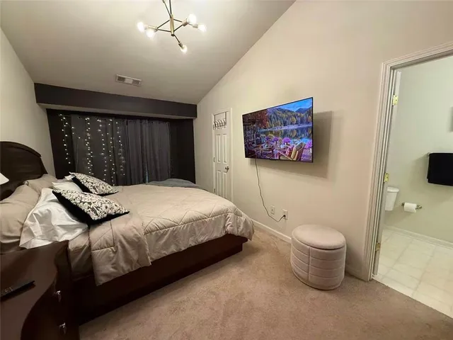 a bedroom with a large bed and a painting on the wall