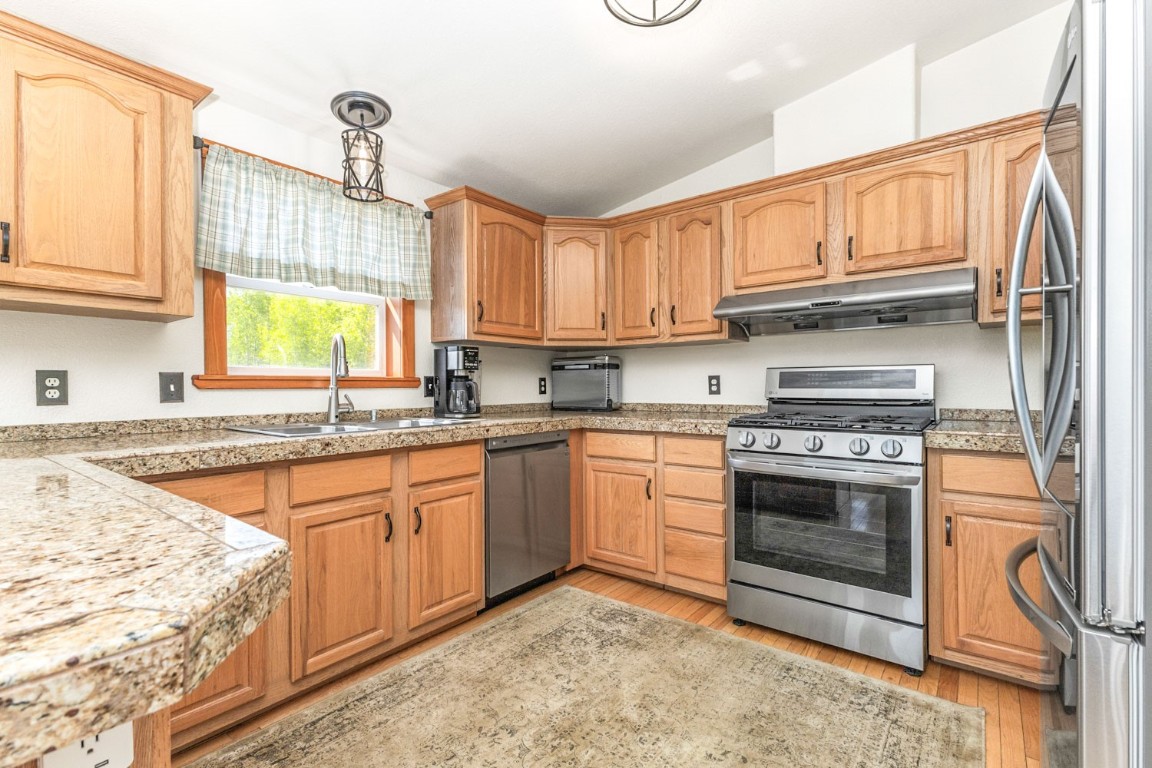 26870 Beaver Canyon Drive Clark, CO 80428 - Photo 13 of 50 a kitchen with stainless steel appliances granite countertop a sink a stove and a refrigerator
