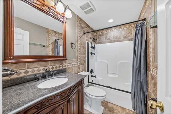 a bathroom with a granite countertop sink toilet and shower