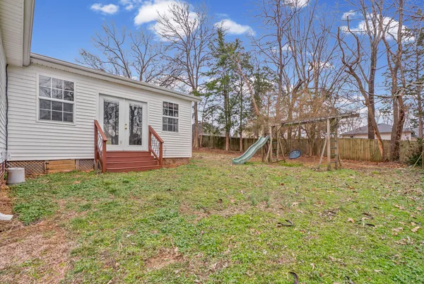 a view of a house with backyard and a tree