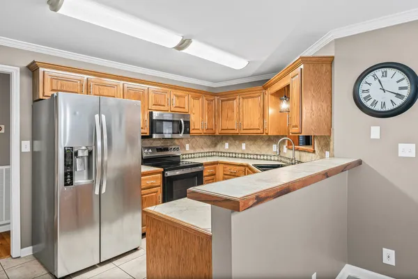 a kitchen with stainless steel appliances granite countertop a refrigerator a stove and a sink
