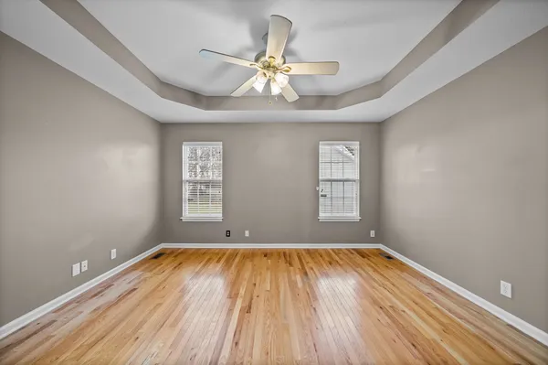 a view of room with window ceiling fan and hardwood floor