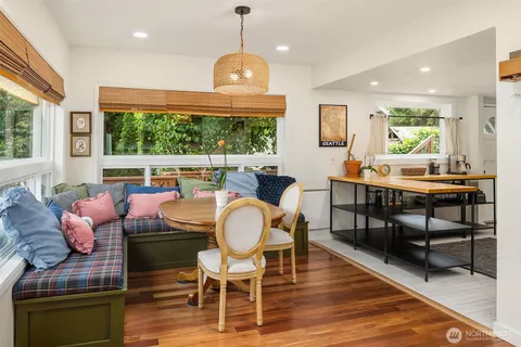 a dining room with wooden floor a chandelier a glass table and chairs