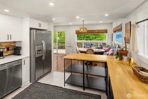 a kitchen with stainless steel appliances granite countertop a refrigerator a stove and a sink with wooden floor