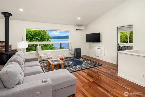 a living room with furniture a flat screen tv and a large window