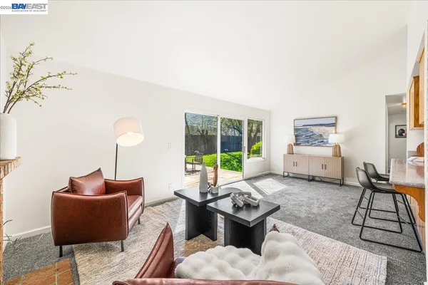 a living room with furniture a fireplace and a glass door