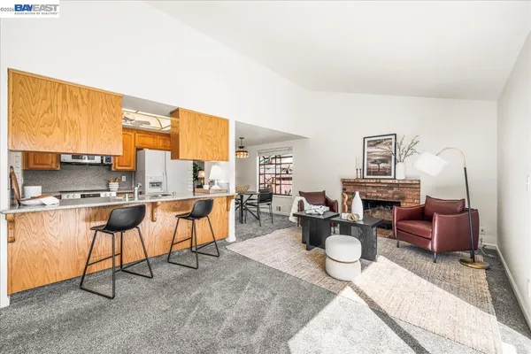 a living room with furniture a fireplace and large windows